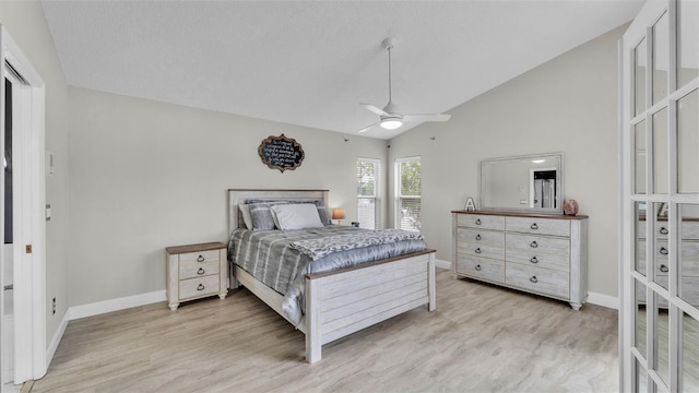 bedroom with baseboards, light wood finished floors, ceiling fan, and high vaulted ceiling