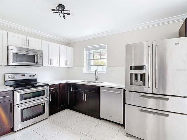 10764 Lenox Rd, Hollywood, FL 33026 - kitchen featuring appliances with stainless steel finishes, a sink, ornamental molding, light tile patterned flooring, and light countertops