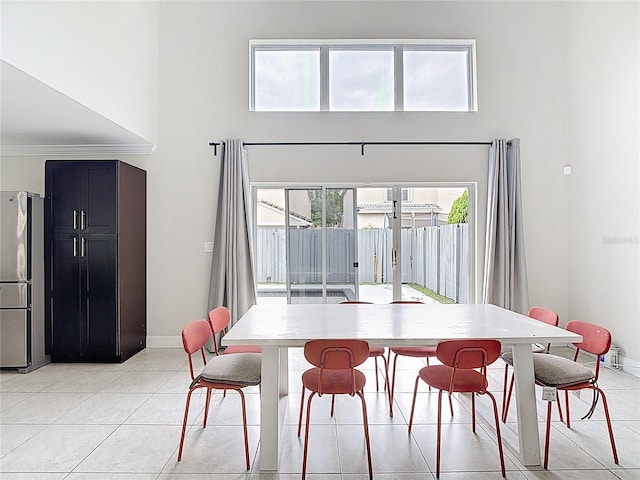 10764 Lenox Rd, Hollywood, FL 33026 - dining room featuring a high ceiling, healthy amount of natural light, light tile patterned floors, baseboards, and crown molding