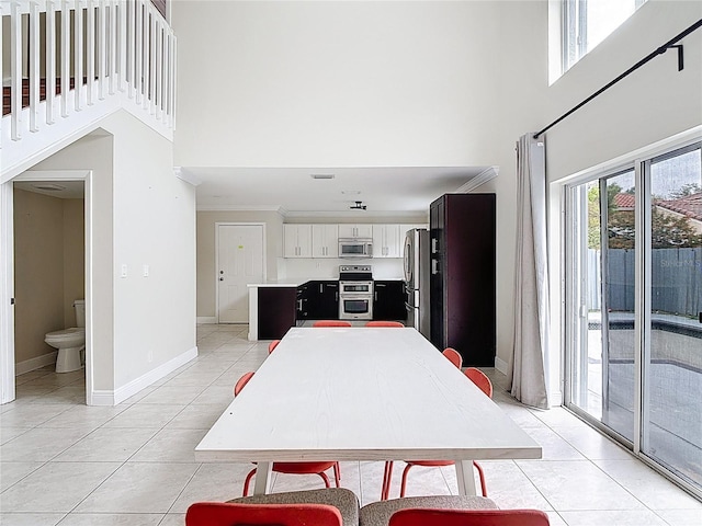 10764 Lenox Rd, Hollywood, FL 33026 - dining area with a high ceiling, light tile patterned floors, baseboards, and ornamental molding