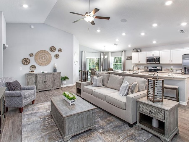 living room featuring lofted ceiling, wood finished floors, visible vents, recessed lighting, and a ceiling fan