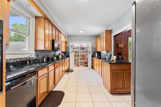 716 S Franklin Pl, Lakeland, FL 33815 - kitchen with black appliances, light tile patterned flooring, backsplash, a sink, and brown cabinetry