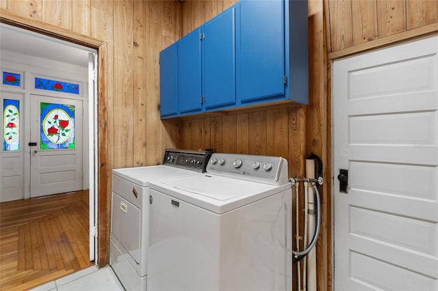 716 S Franklin Pl, Lakeland, FL 33815 - clothes washing area with cabinet space, wooden walls, and washer and clothes dryer