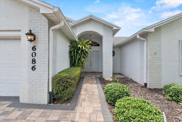 6086 Swallow Dr, Lakeland, FL 33809 - doorway to property featuring an attached garage and stucco siding