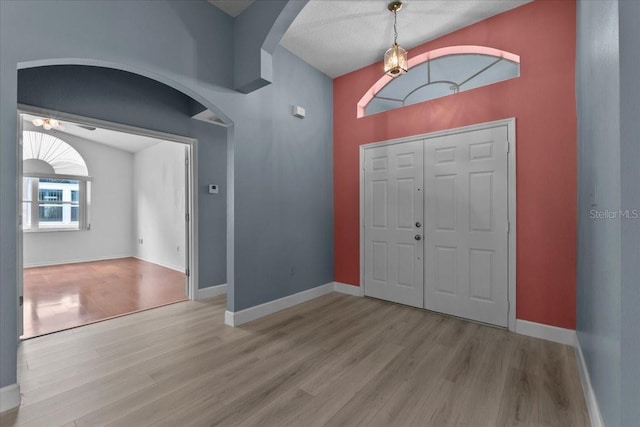 6086 Swallow Dr, Lakeland, FL 33809 - foyer entrance with wood finished floors, arched walkways, baseboards, a ceiling fan, and lofted ceiling