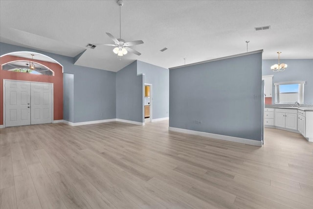 6086 Swallow Dr, Lakeland, FL 33809 - unfurnished living room with vaulted ceiling, ceiling fan, a chandelier, light wood-style flooring, and baseboards