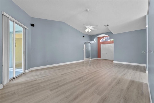 6086 Swallow Dr, Lakeland, FL 33809 - unfurnished living room featuring arched walkways, vaulted ceiling, ceiling fan, light wood-style flooring, and baseboards