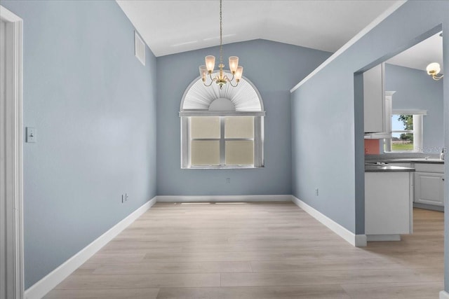 6086 Swallow Dr, Lakeland, FL 33809 - unfurnished dining area with a chandelier, light wood-style flooring, lofted ceiling, and baseboards