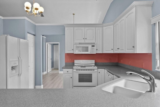 6086 Swallow Dr, Lakeland, FL 33809 - kitchen with white appliances, a sink, a chandelier, white cabinetry, and vaulted ceiling