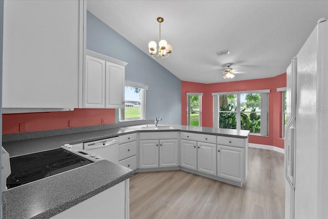 6086 Swallow Dr, Lakeland, FL 33809 - kitchen with white appliances, a sink, a peninsula, a ceiling fan, and white cabinets