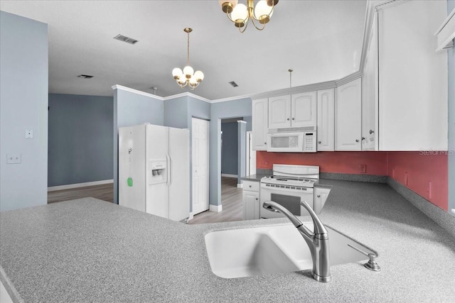 6086 Swallow Dr, Lakeland, FL 33809 - kitchen featuring white appliances, a chandelier, white cabinetry, and a sink