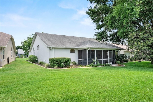 6086 Swallow Dr, Lakeland, FL 33809 - back of house with a lawn, a sunroom, stucco siding, and a shingled roof