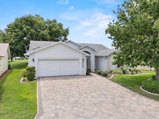 6086 Swallow Dr, Lakeland, FL 33809 - ranch-style home featuring a front lawn, decorative driveway, a garage, and roof with shingles