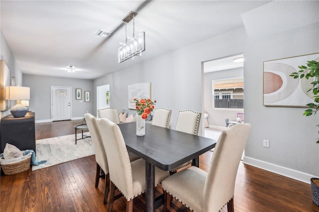 dining room with baseboards, dark wood-type flooring, and a chandelier