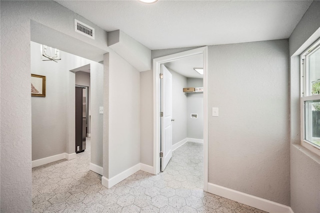 hall with a chandelier and baseboards