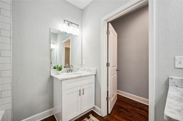 bathroom featuring wood finished floors, vanity, and baseboards