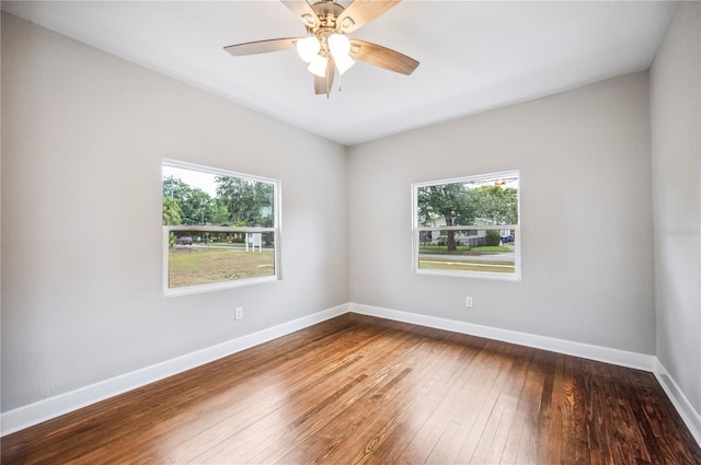 unfurnished room featuring plenty of natural light, hardwood / wood-style flooring, baseboards, and a ceiling fan