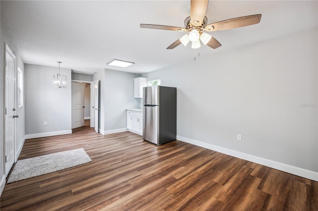empty room featuring baseboards, dark wood-type flooring, and a ceiling fan