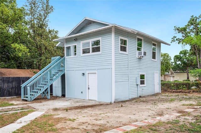 rear view of property with stairway and fence