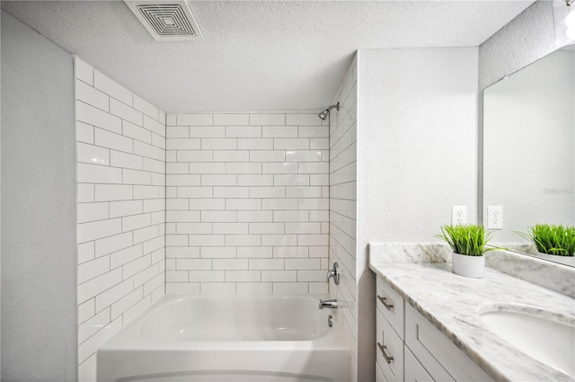 bathroom featuring washtub / shower combination, a textured ceiling, and vanity