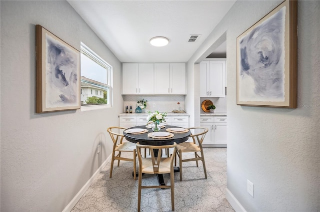 dining room with baseboards and light flooring