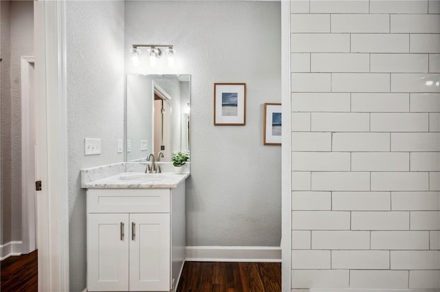 bathroom featuring wood finished floors, vanity, and baseboards