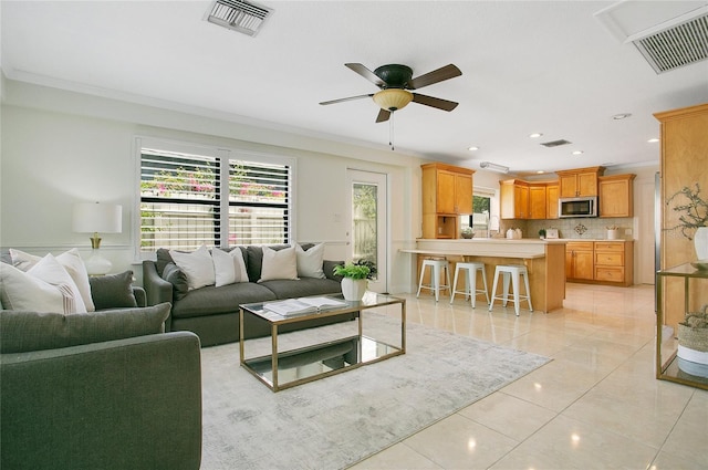living area featuring light tile patterned flooring, ceiling fan, recessed lighting, and ornamental molding