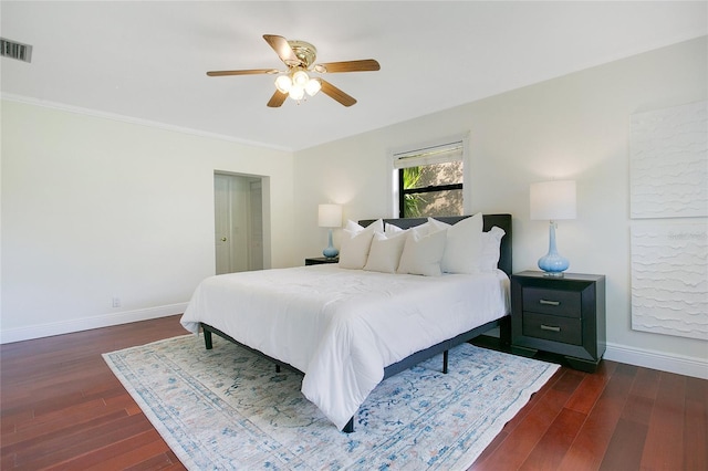 bedroom featuring baseboards, dark wood-style floors, a ceiling fan, and crown molding