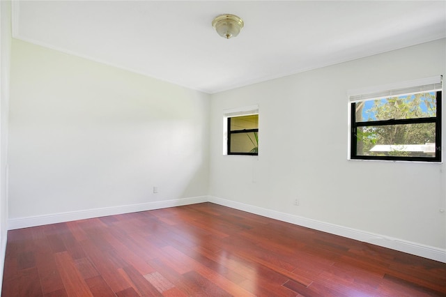 spare room with wood finished floors and baseboards
