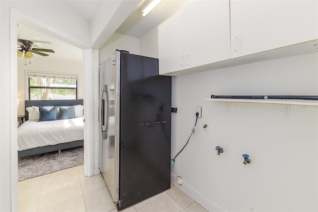 laundry room with cabinet space, a ceiling fan, light tile patterned flooring, baseboards, and washer hookup