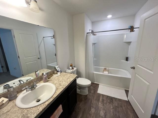 879 Grandin St, Davenport, FL 33837 - full bath featuring wood finished floors, toilet, shower / bath combo, and vanity