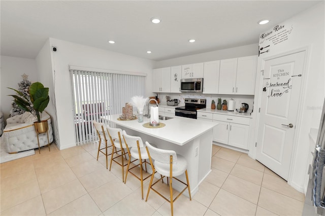 2039 Rosewood Cir, Lakeland, FL 33810 - kitchen featuring appliances with stainless steel finishes, a sink, a kitchen breakfast bar, white cabinets, and a center island with sink