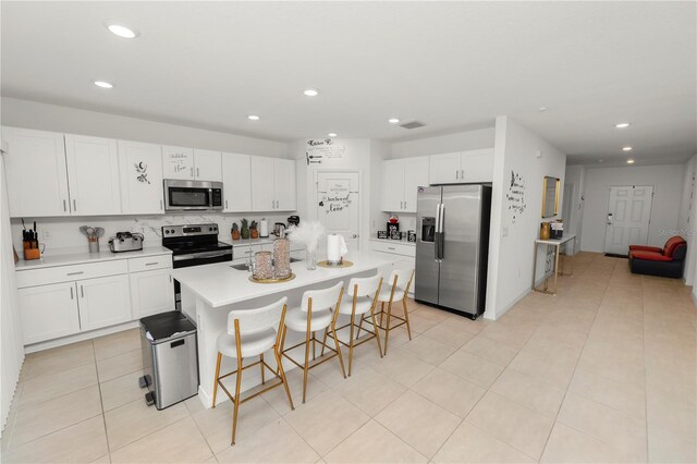 2039 Rosewood Cir, Lakeland, FL 33810 - kitchen featuring appliances with stainless steel finishes, recessed lighting, a kitchen breakfast bar, white cabinetry, and light countertops