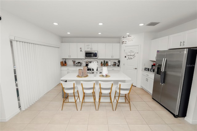 2039 Rosewood Cir, Lakeland, FL 33810 - kitchen with appliances with stainless steel finishes, light countertops, a kitchen breakfast bar, white cabinets, and recessed lighting