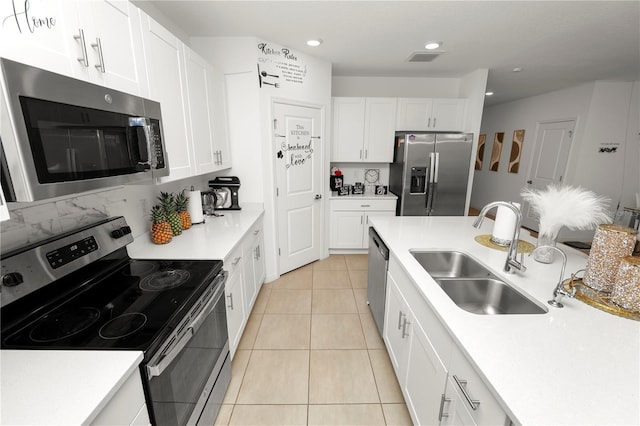 2039 Rosewood Cir, Lakeland, FL 33810 - kitchen featuring appliances with stainless steel finishes, a sink, light countertops, white cabinets, and light tile patterned floors
