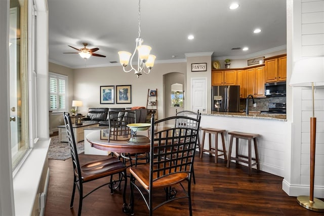 8909 N Campbell Rd, Lakeland, FL 33810 - dining space featuring dark wood-style flooring, recessed lighting, ceiling fan, crown molding, and arched walkways