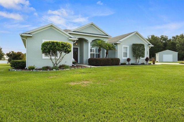 8909 N Campbell Rd, Lakeland, FL 33810 - ranch-style house with a front lawn, stucco siding, a detached garage, and an outbuilding