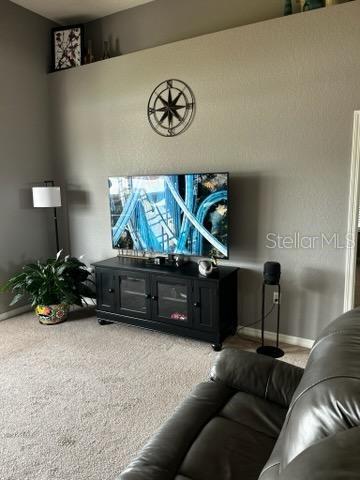 living area with light colored carpet and baseboards
