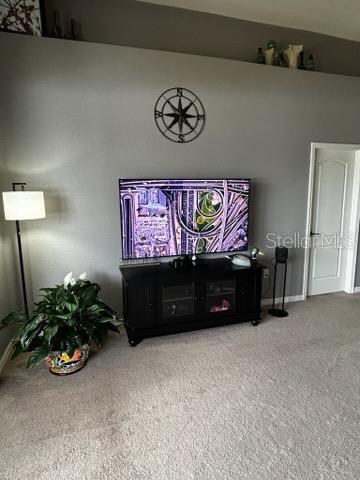 carpeted living room featuring baseboards