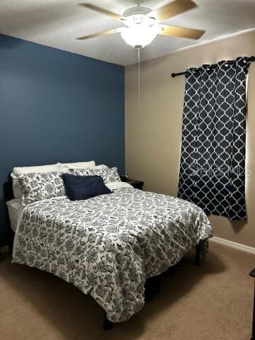 carpeted bedroom featuring a ceiling fan and baseboards