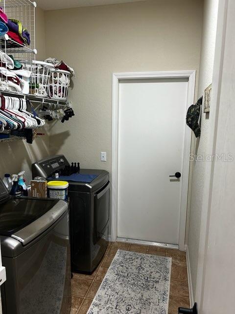 washroom featuring washer and dryer and tile patterned flooring