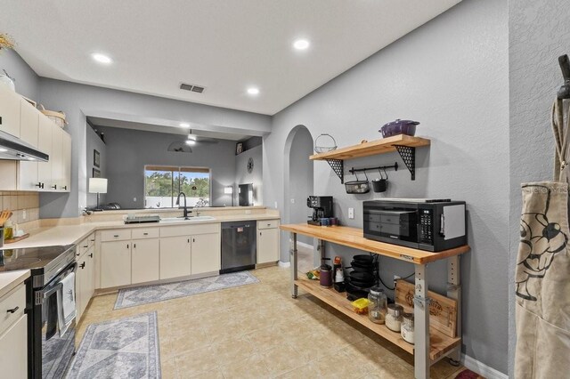 4041 Byrds Crossing Dr, Lakeland, FL 33812 - kitchen with black appliances, a sink, arched walkways, light countertops, and recessed lighting
