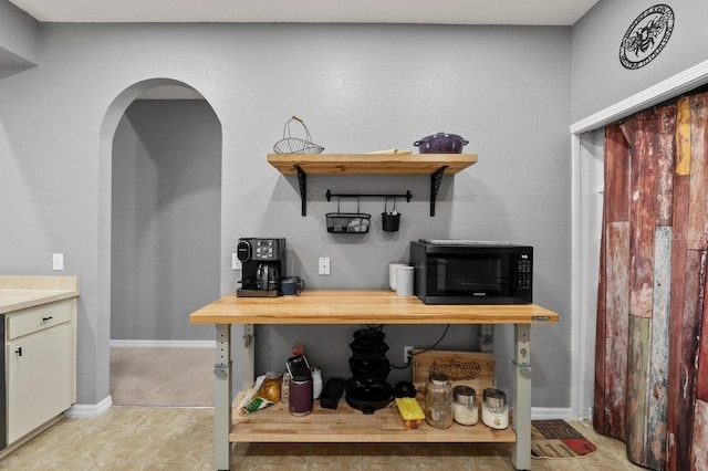 4041 Byrds Crossing Dr, Lakeland, FL 33812 - bar featuring black microwave, arched walkways, and baseboards