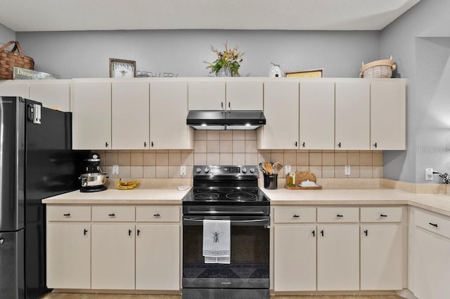 4041 Byrds Crossing Dr, Lakeland, FL 33812 - kitchen with under cabinet range hood, black range with electric cooktop, freestanding refrigerator, and tasteful backsplash