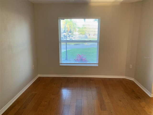 empty room with wood finished floors and baseboards