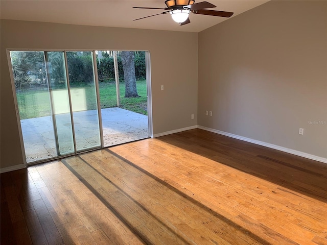 empty room featuring a ceiling fan, wood-type flooring, and baseboards