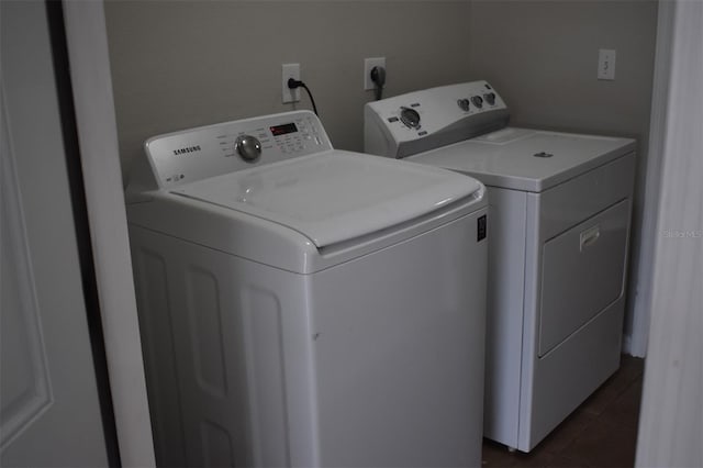 laundry area featuring washer and clothes dryer and dark tile patterned floors