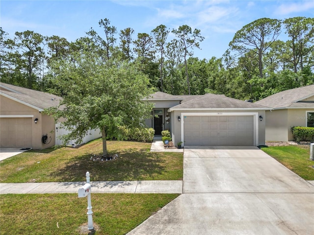 1825 Wallace Manor Ln, Winter Haven, FL 33880 - view of front facade featuring an attached garage, a front yard, stucco siding, driveway, and roof with shingles