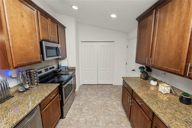 1825 Wallace Manor Ln, Winter Haven, FL 33880 - kitchen featuring stainless steel appliances, light stone countertops, recessed lighting, and lofted ceiling