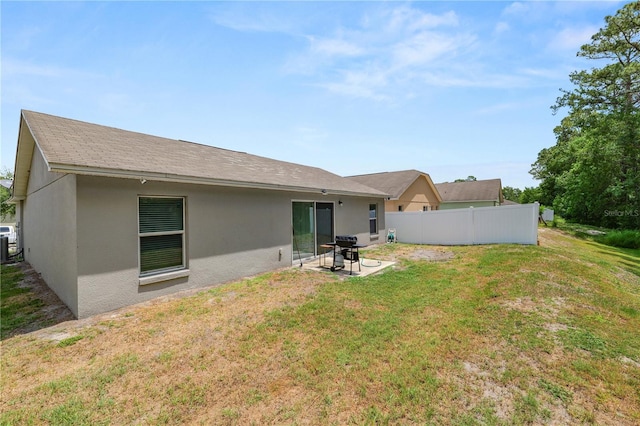 1825 Wallace Manor Ln, Winter Haven, FL 33880 - rear view of house with stucco siding, a patio area, and central AC